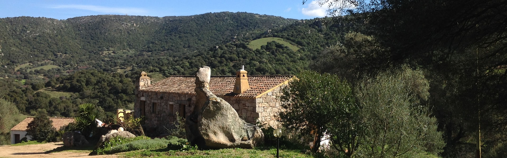 l'edificio centrale dell'agriturismo Lu Rotu, rivestito in granito, con un panorama della campagna circostante